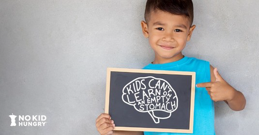 Image of a child holding a small chalkboard